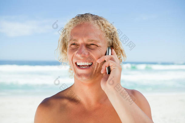 站在沙滩上用<strong>手机</strong>微<strong>笑</strong>的男人