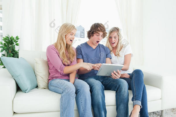 三个朋友震惊地看着平板电脑的屏幕