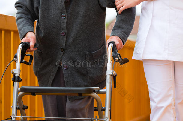 年轻护士，女老年人，带步行架