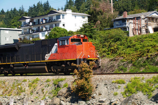 橙色和黑色的火车引擎在铁轨上行驶