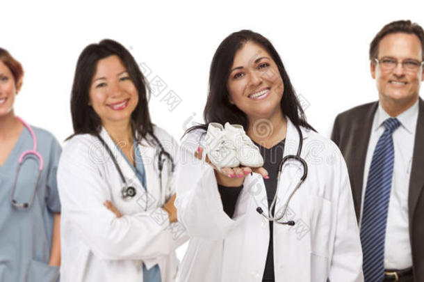 西班牙裔女医生或护士，穿着婴儿鞋，身后有辅助人员