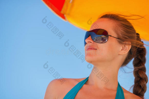 风大的海滩上戴着太阳镜的快乐女人