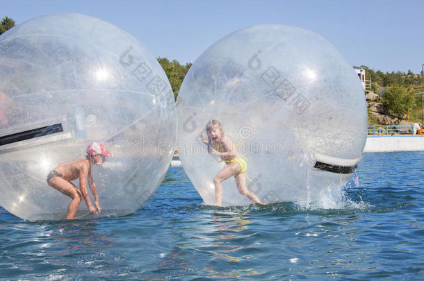 孩子们在漂浮在水上的气球里。