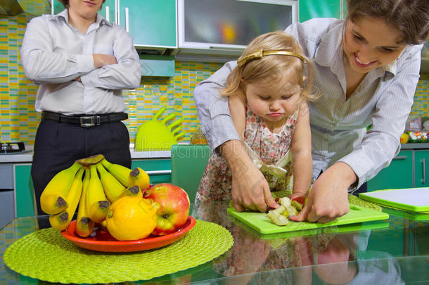 女孩和她母亲正在切水果