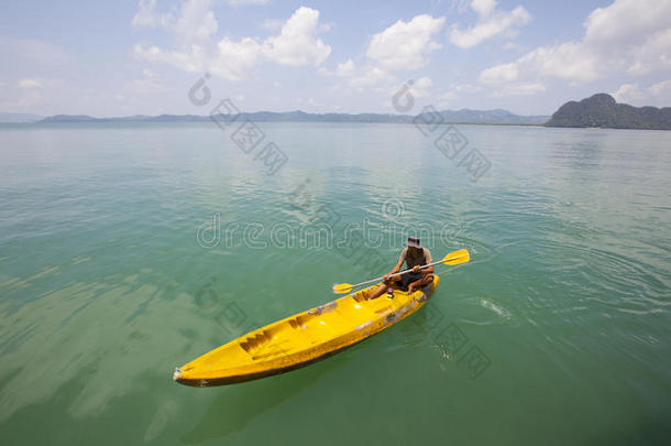 在热带岛屿上划独木舟的年轻人