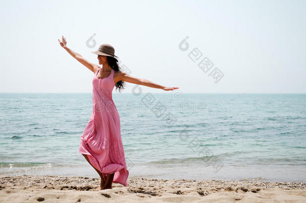 海滩上穿着粉红色长裙的美女