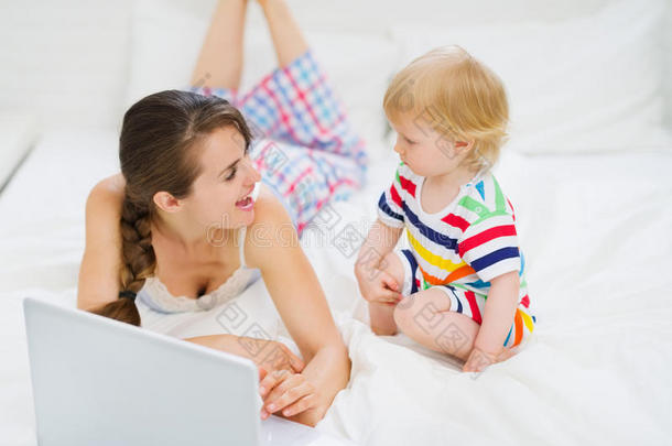 年轻妈妈<strong>给宝宝</strong>看笔记本电脑里的东西