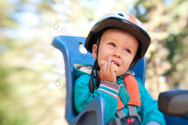 坐在自行车儿童座椅上的小男孩