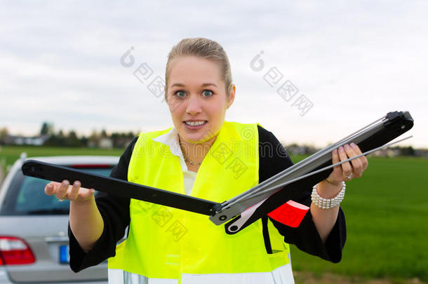 街上有三角<strong>警示牌</strong>的年轻女子