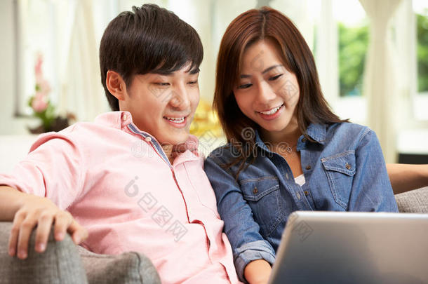 <strong>中国年</strong>轻夫妇在放松的同时使用笔记本电脑