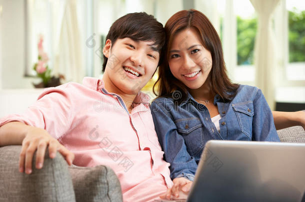 中国年轻夫妇在放松的同时使用笔记本电脑