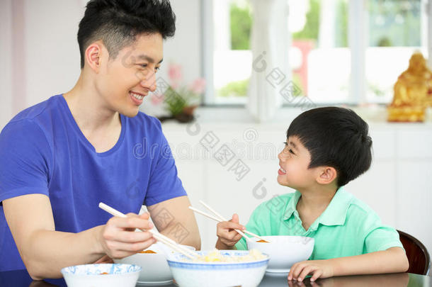 坐在家里吃饭的中国父子