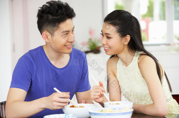 坐在家里吃饭的中国年轻夫妇