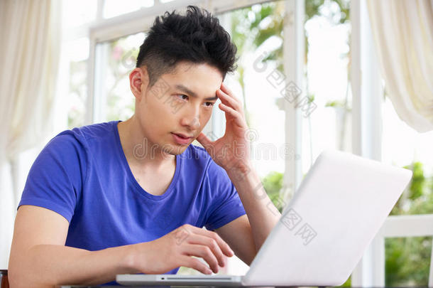 忧心忡忡的中国年轻人在家使用笔记本电脑