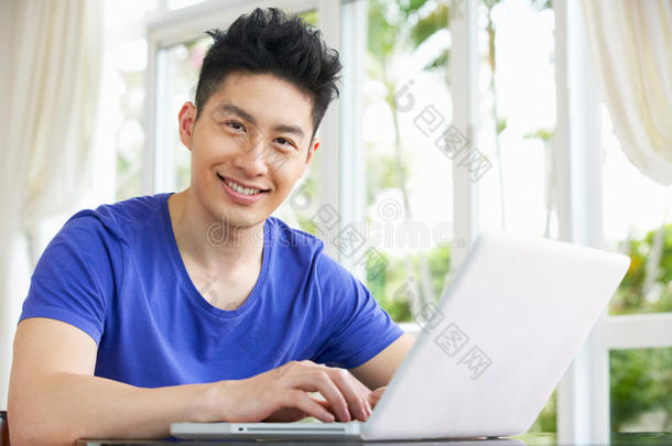 忧心忡忡的中国年轻人在家使用笔记本电脑