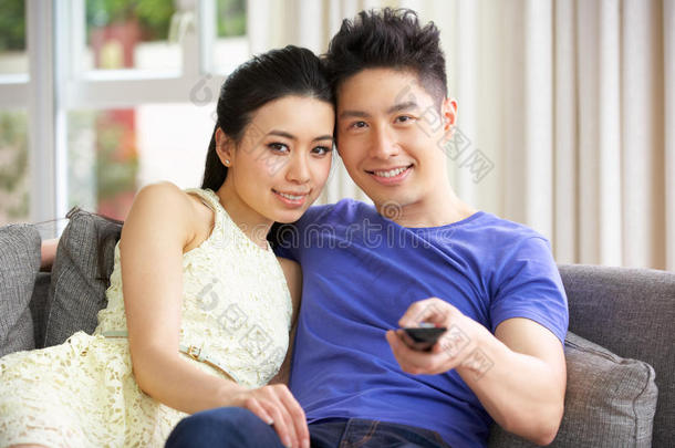 中国年轻夫妇在家沙发上看电视