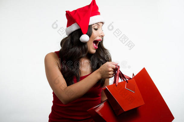 黑发女人拿着圣诞红的购物袋