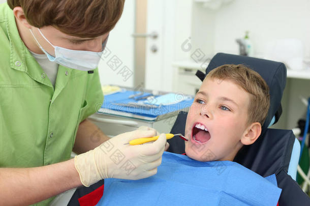 牙医在牙科诊所看男孩的牙齿