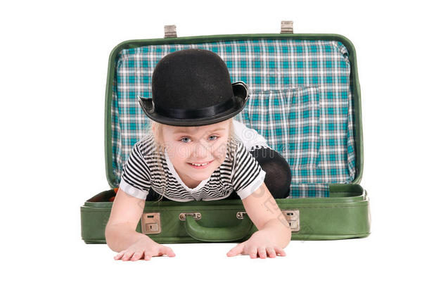 孩子坐在一个旧的绿色手提箱里
