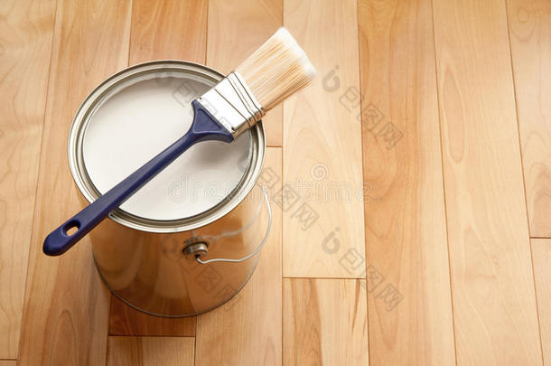 木地板上的漆刷和一罐油漆