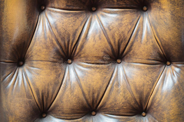 一张有纽扣的棕色旧沙发的细节