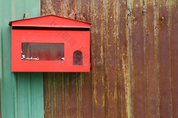 生锈铁栅栏上的红色邮箱