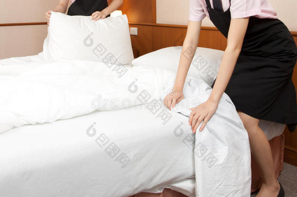 女服务员在酒店房间铺床