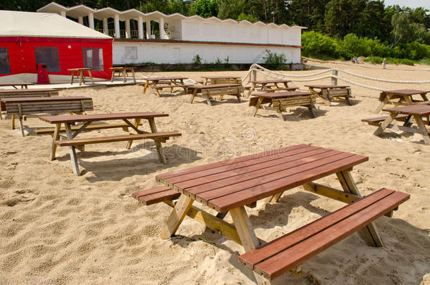 沙滩上的桌子和长凳，还有巨大的咖啡馆帐篷。