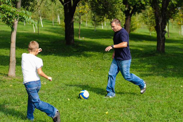 小男孩和他父亲踢足球