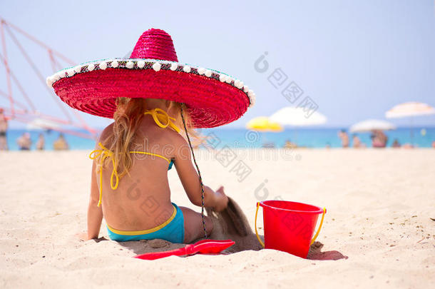 戴着红<strong>帽子</strong>坐在<strong>沙滩</strong>上的婴儿