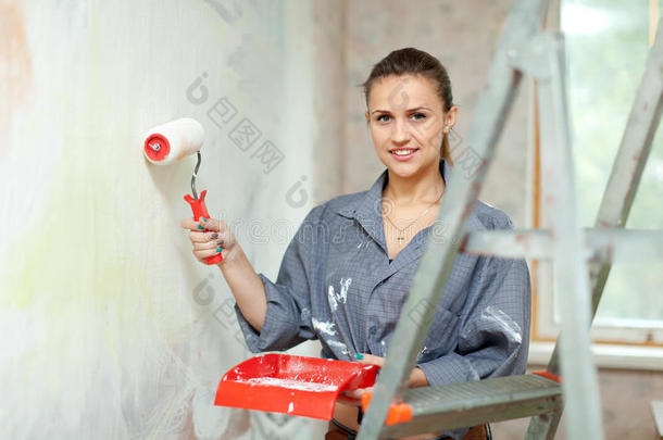 妇女在家粉刷墙壁