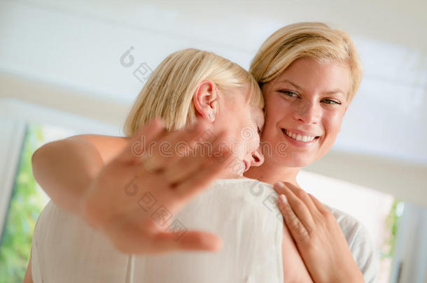 快乐的女人向母亲展示订婚戒指