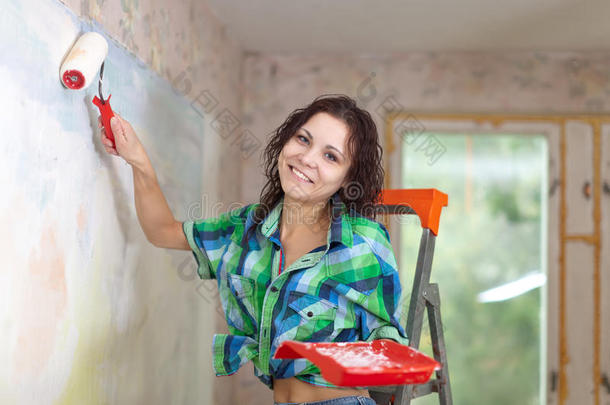 妇女在家粉刷墙壁