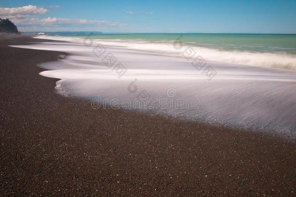 在阳光明媚的卵石海滩上冲浪