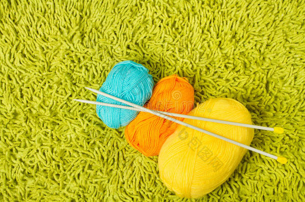 在绿地毯上编织纱线球和针
