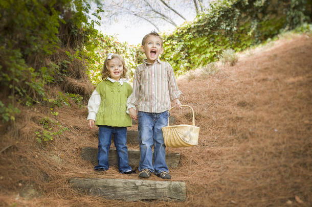 两个孩子提着篮子走在木台阶上。