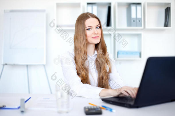 <strong>年轻笑</strong>容可掬的女商人在笔记本电脑上工作