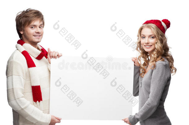 年轻幸福的圣诞夫妇举着大牌子