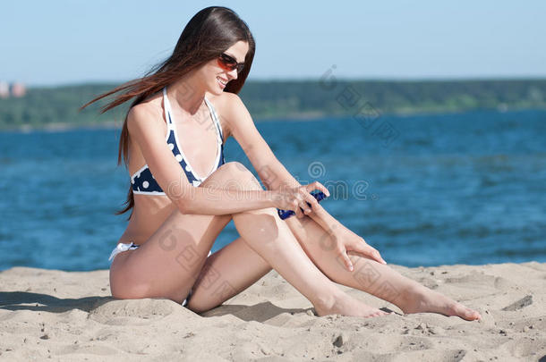 美女在海滩涂防晒霜