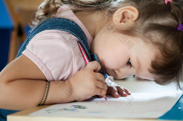 可爱的小女孩在<strong>学前班</strong>用笔画画