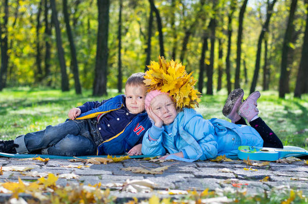 孩子们在秋天的公园里紧紧地躺在一起