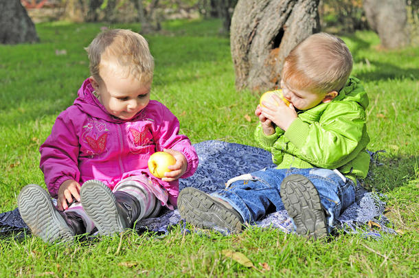 两个小孩坐在绿地上