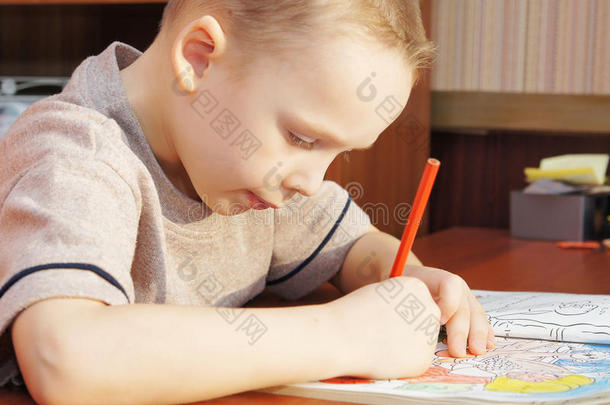 小男孩正在用铅笔在<strong>抄</strong>写本上画画