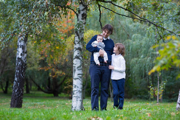秋天的一天，父亲和两个孩子在森林里散步