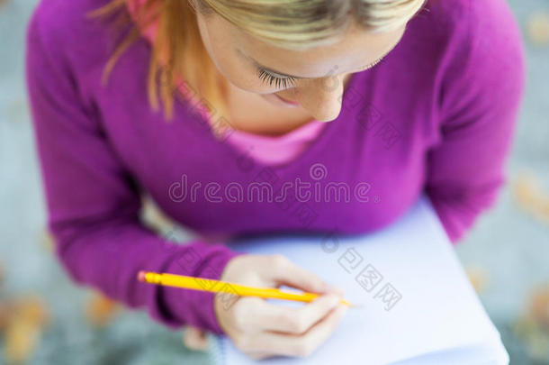 女学生在笔记本上写字