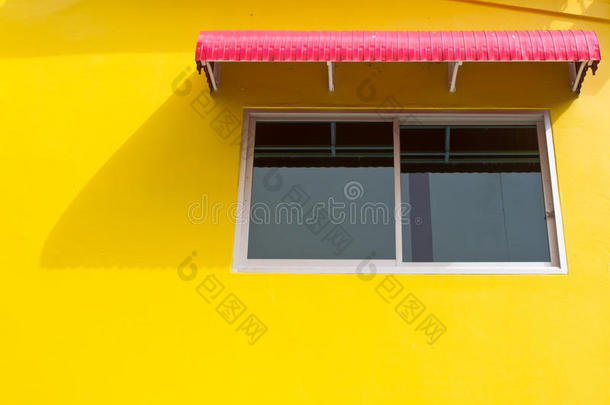 黄色墙壁上有红色挡板的窗户