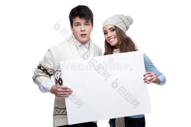 年轻微笑的冬日情侣举着大牌子