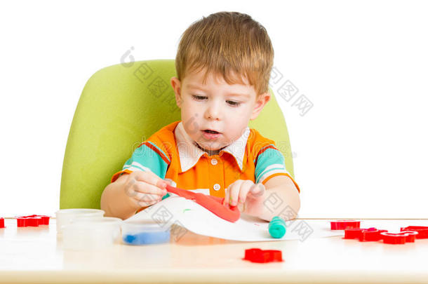 坐在桌边玩彩泥的孩子
