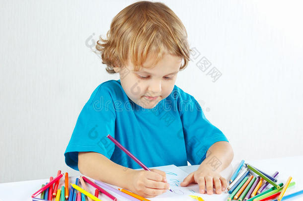 小男孩用彩色铅笔在白色背景上画画