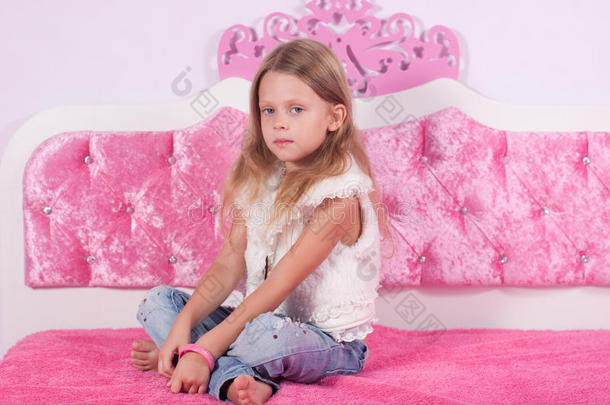 坐在粉红色床上的小女孩